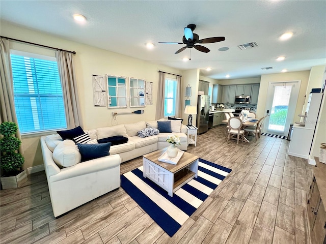 living room featuring light wood-type flooring and ceiling fan