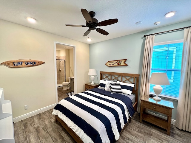 bedroom featuring dark hardwood / wood-style flooring, a textured ceiling, ceiling fan, and ensuite bath