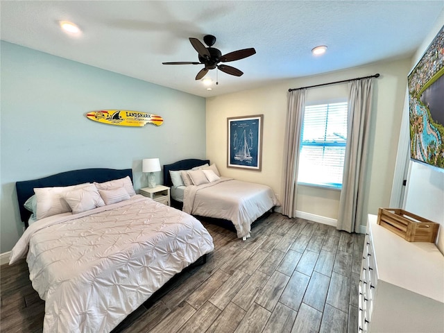 bedroom featuring a textured ceiling, dark wood-type flooring, and ceiling fan