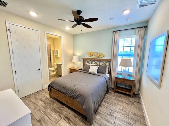 bedroom with ensuite bathroom, ceiling fan, a textured ceiling, and light wood-type flooring