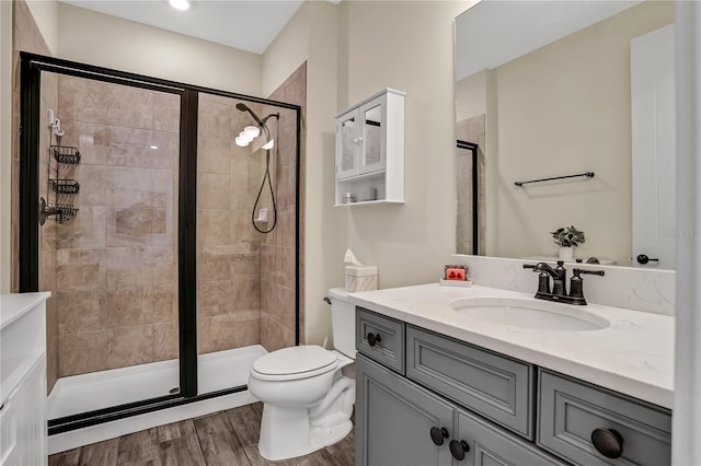 bathroom featuring hardwood / wood-style flooring, vanity, toilet, and an enclosed shower