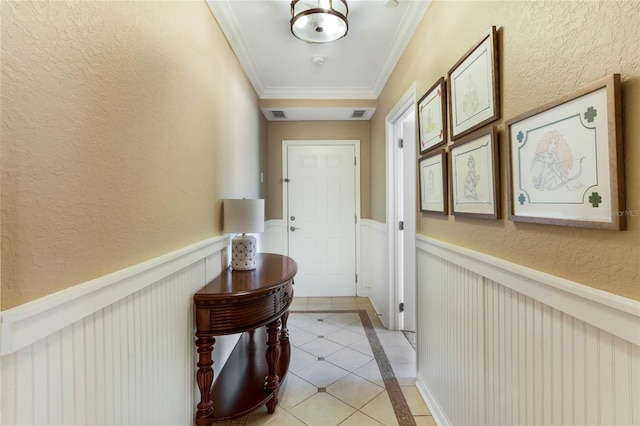 hallway featuring light tile floors and ornamental molding