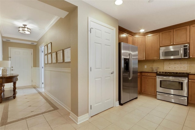 kitchen featuring light tile flooring, backsplash, appliances with stainless steel finishes, and crown molding