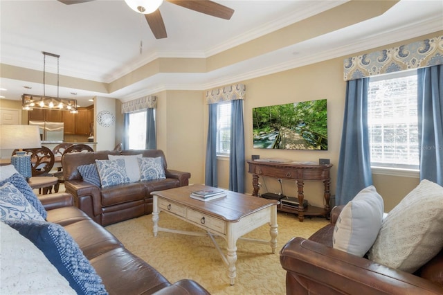 carpeted living room with ceiling fan and ornamental molding