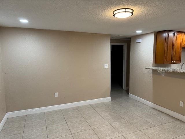 tiled spare room with a textured ceiling