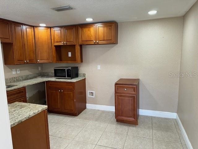 kitchen featuring light stone countertops and light tile floors