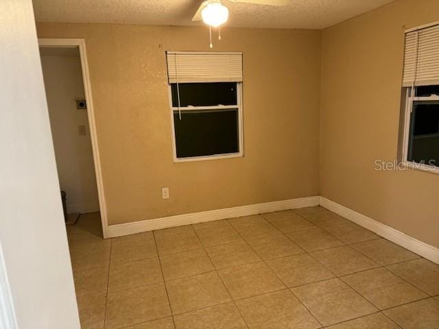 tiled spare room featuring ceiling fan and a textured ceiling