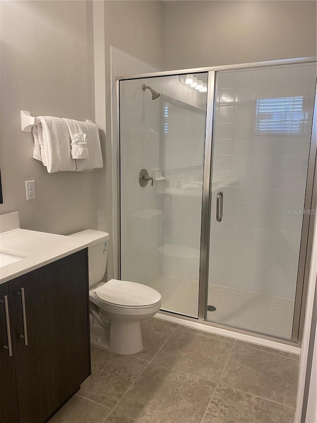 bathroom with toilet, a shower with door, and vanity