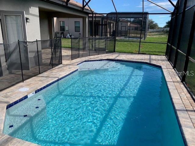 view of pool featuring glass enclosure