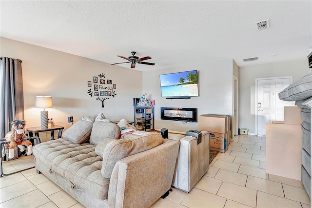 tiled living room with ceiling fan and a textured ceiling