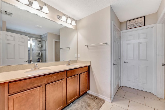 bathroom featuring double sink, a textured ceiling, tile floors, and large vanity