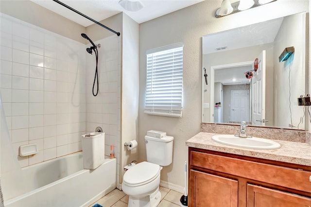 full bathroom with tiled shower / bath, toilet, vanity with extensive cabinet space, and tile floors