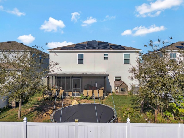 back of house with solar panels and a sunroom