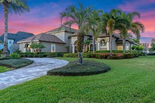 mediterranean / spanish-style house featuring stucco siding, a lawn, and curved driveway