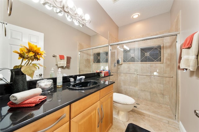 bathroom with toilet, walk in shower, vanity, tile patterned floors, and a textured ceiling