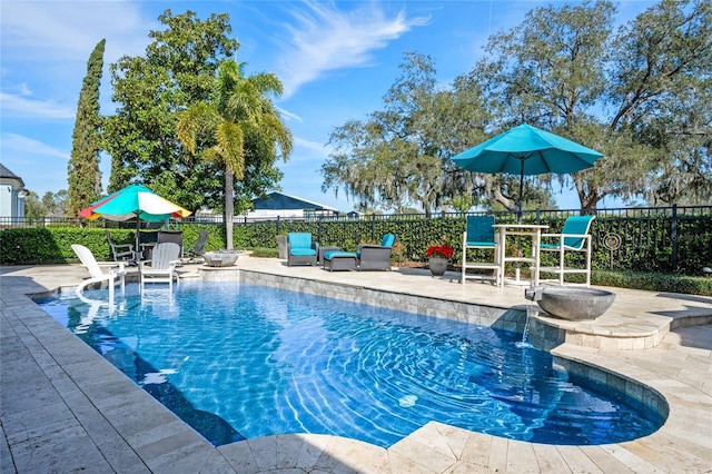 view of swimming pool with pool water feature and a patio area