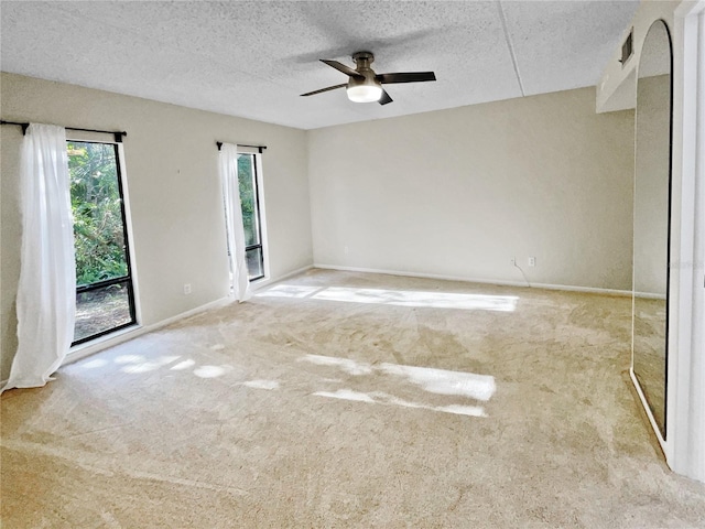 unfurnished room with light colored carpet, a textured ceiling, and ceiling fan