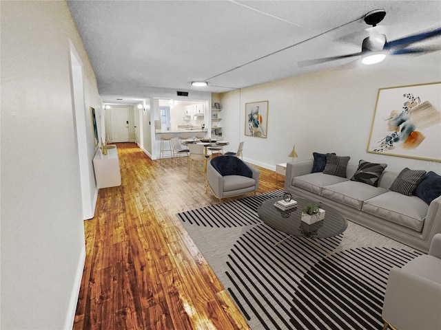 living room with ceiling fan, light hardwood / wood-style floors, and a textured ceiling