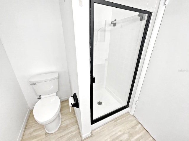 bathroom featuring an enclosed shower, hardwood / wood-style flooring, and toilet