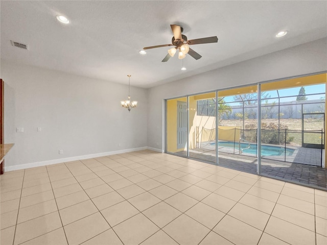 empty room with ceiling fan with notable chandelier and light tile patterned flooring