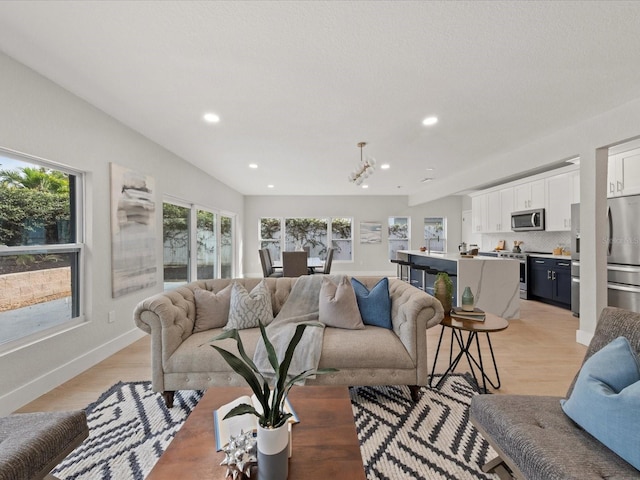 living room with an inviting chandelier and light hardwood / wood-style floors