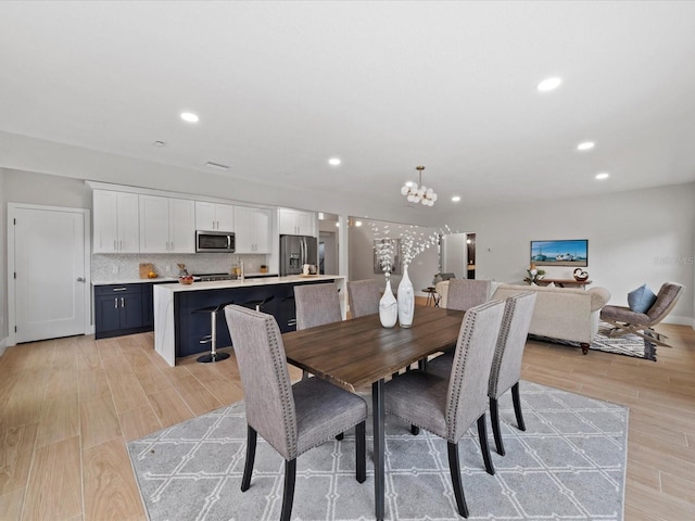 dining area with a chandelier and light hardwood / wood-style flooring