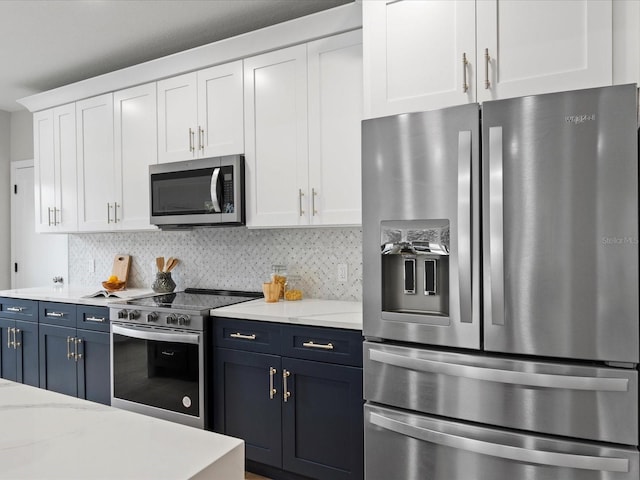 kitchen with white cabinets, light stone countertops, tasteful backsplash, and appliances with stainless steel finishes