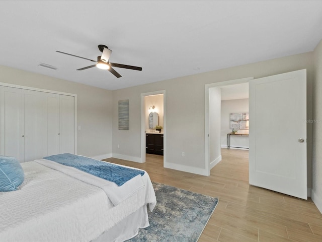 bedroom featuring ensuite bath, a closet, ceiling fan, and light wood-type flooring