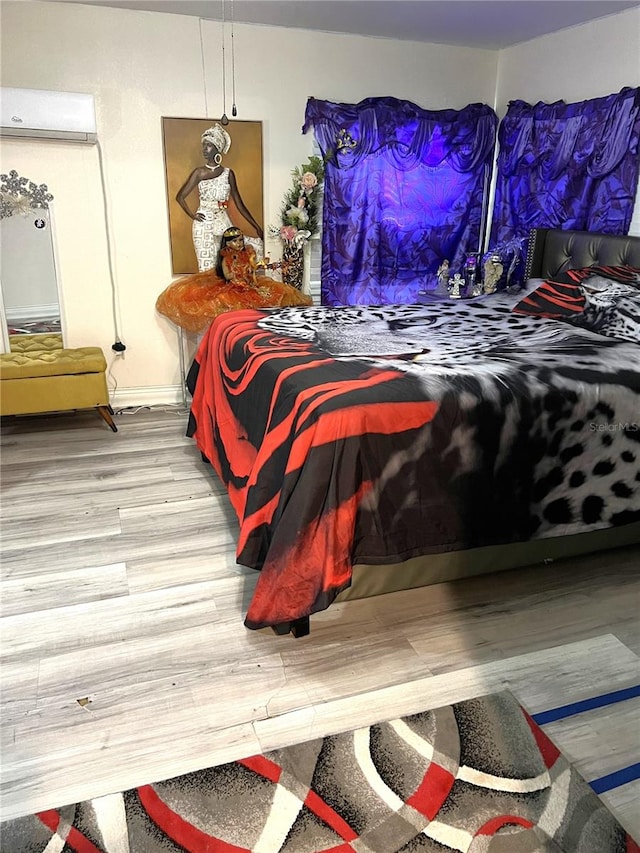 bedroom featuring a wall mounted AC and light wood-type flooring