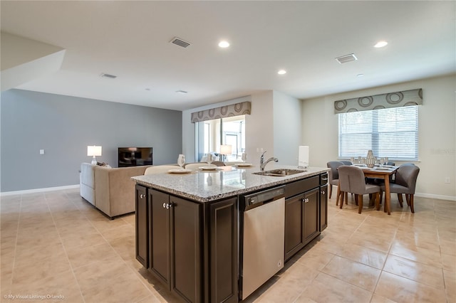 kitchen featuring plenty of natural light, stainless steel dishwasher, sink, and a kitchen island with sink