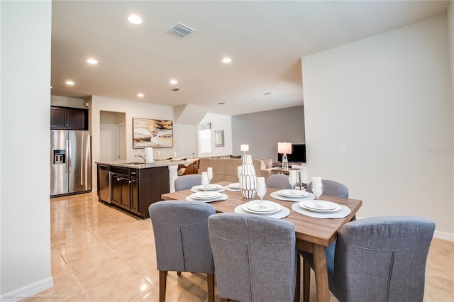 tiled dining room featuring sink