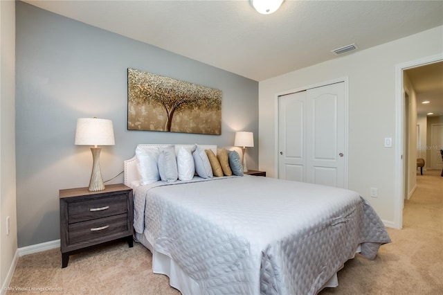 bedroom with light colored carpet and a closet