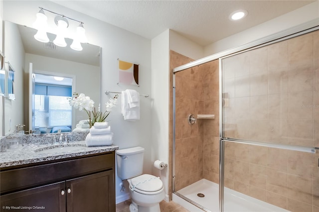 bathroom with toilet, a textured ceiling, vanity, walk in shower, and an inviting chandelier