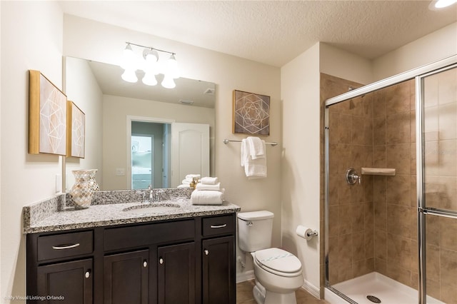 bathroom featuring an enclosed shower, an inviting chandelier, a textured ceiling, vanity with extensive cabinet space, and toilet