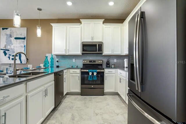 kitchen with light tile flooring, white cabinetry, appliances with stainless steel finishes, hanging light fixtures, and sink