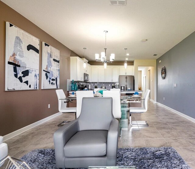 dining area featuring light tile flooring and a notable chandelier