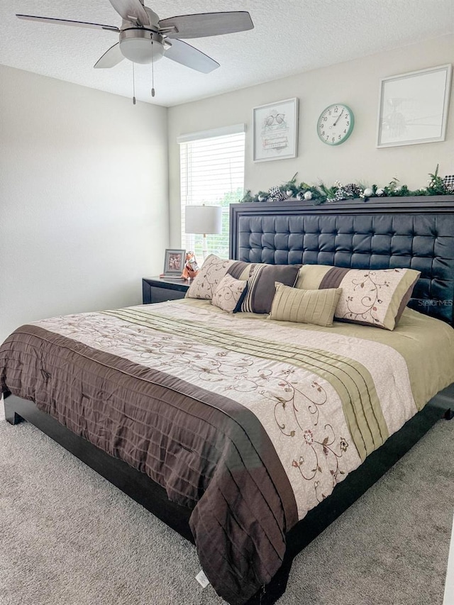 carpeted bedroom featuring a textured ceiling and ceiling fan