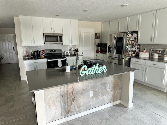 kitchen featuring white cabinets, a center island with sink, and appliances with stainless steel finishes