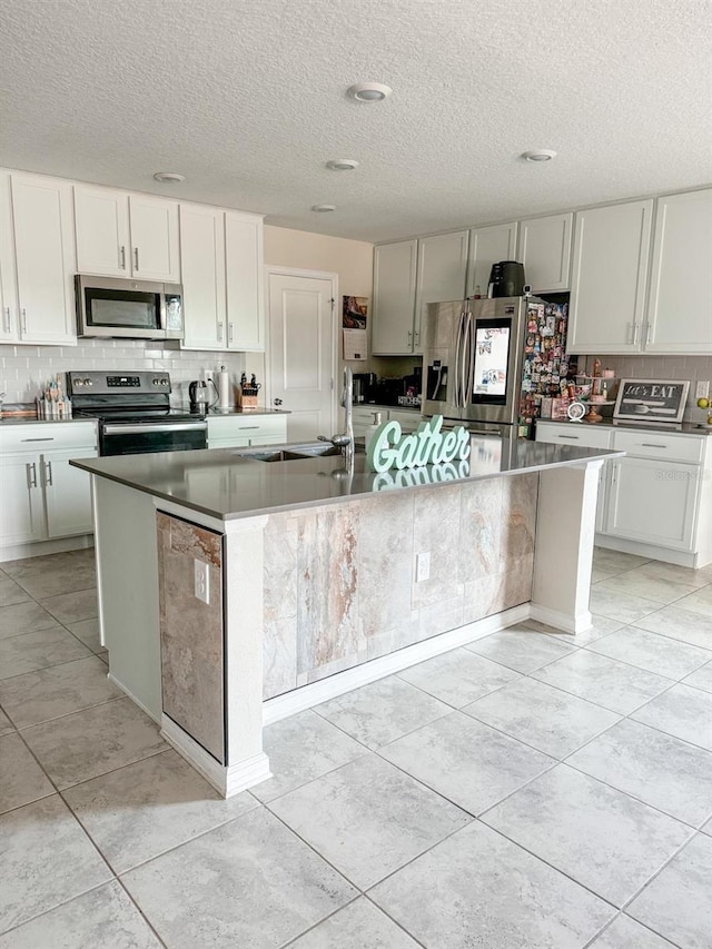 kitchen featuring a large island, sink, white cabinets, decorative backsplash, and stainless steel appliances