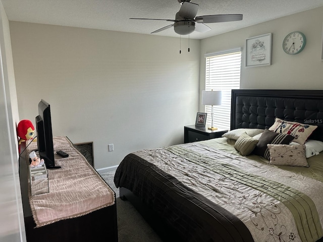 carpeted bedroom with ceiling fan and a textured ceiling