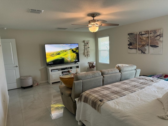 bedroom with ceiling fan, a textured ceiling, and light tile patterned floors