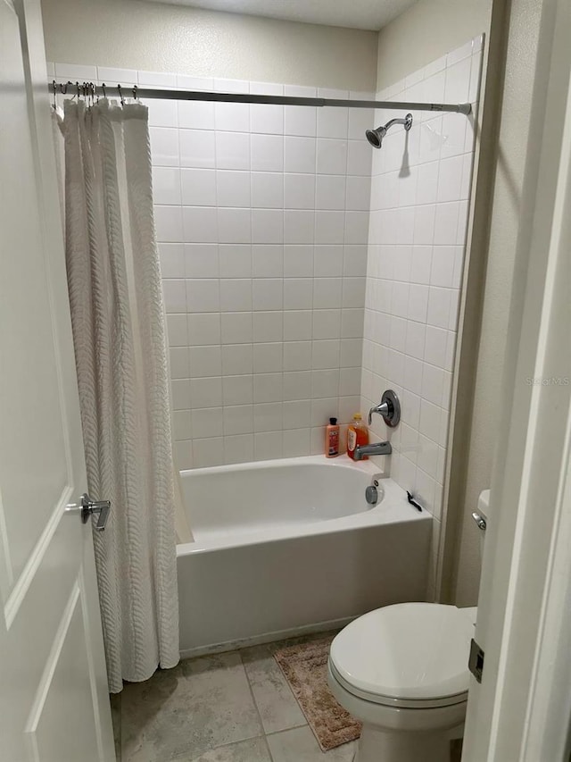 bathroom with toilet, shower / tub combo, and tile patterned flooring