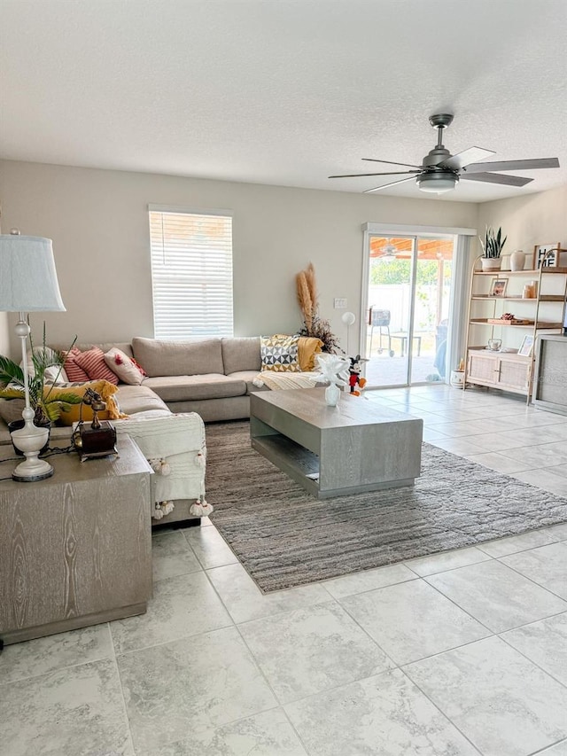 tiled living room featuring ceiling fan and a textured ceiling