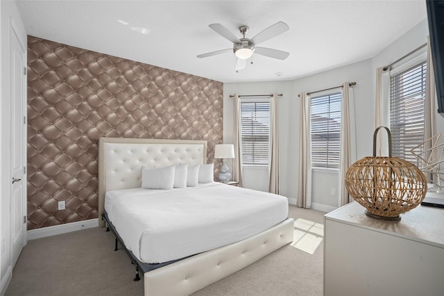 bedroom featuring light carpet, ceiling fan, and multiple windows