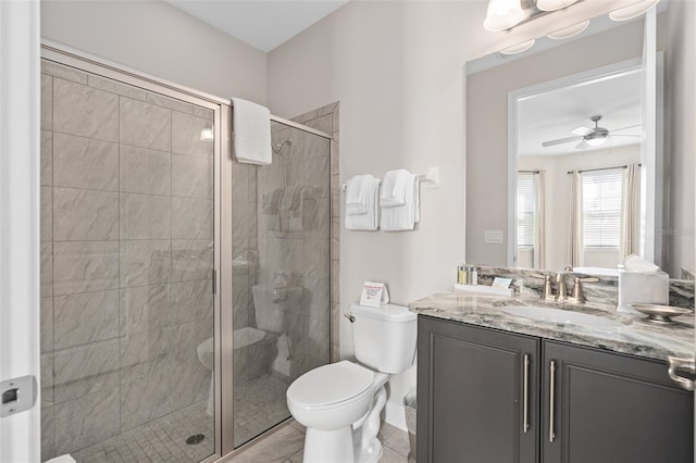 bathroom with toilet, ceiling fan, a shower with door, tile floors, and oversized vanity