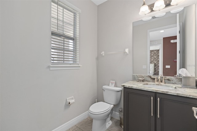 bathroom with toilet, large vanity, and tile floors