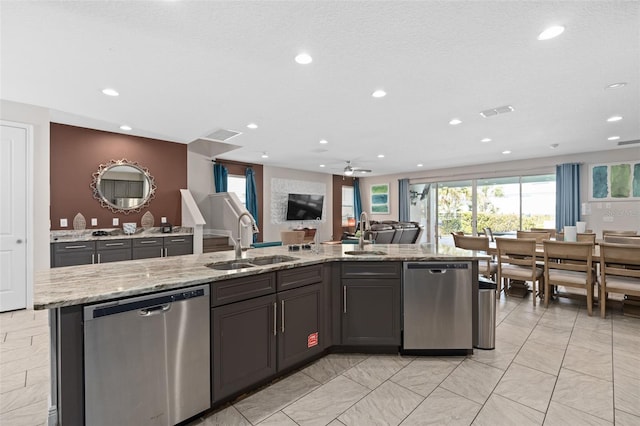 kitchen with light stone counters, ceiling fan, sink, and dishwasher