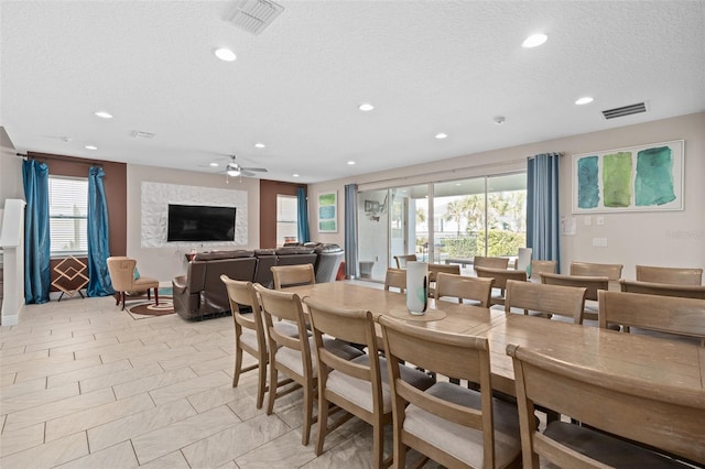 dining area with a textured ceiling, light tile flooring, and ceiling fan