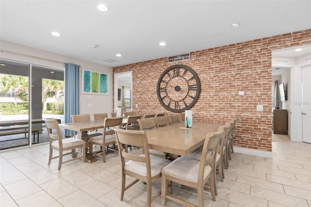 dining area featuring plenty of natural light, brick wall, and light tile flooring