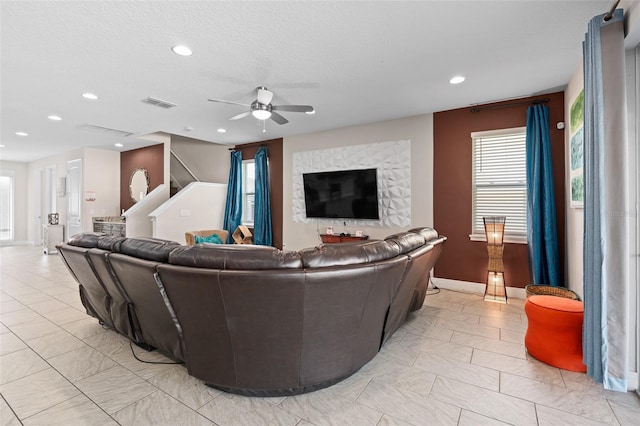 living room with light tile floors, ceiling fan, and a wealth of natural light